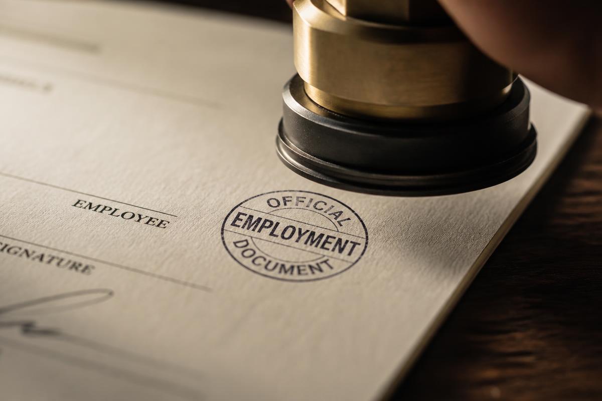 Signed employment documents on a desk
